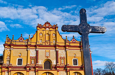 Gelbe Kathedrale in San Christóbal de las Casas mit Kreuz im Vordergrund