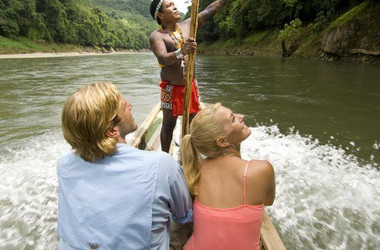 Embera Indianer zeigt Besucherpaar den Regenwald
