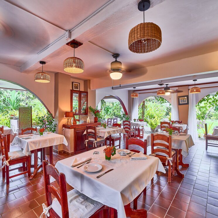 Speisesaal mit Holztischen und gefliestem Boden in Cahuita.