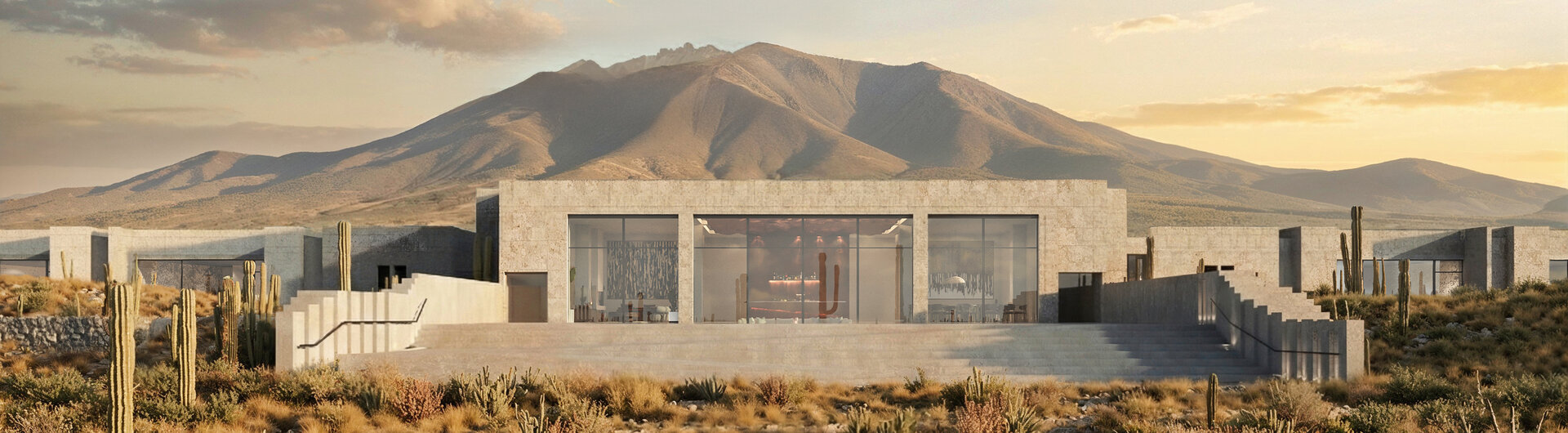 Außenansicht der Casa Gastón bei Uyuni mit moderner Architektur aus Naturstein, großen Glasfronten und Kakteen in karger Andenlandschaft vor Bergkulisse.