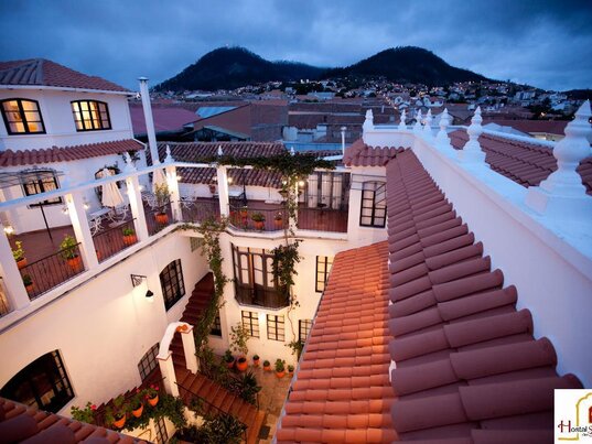 Blick von der Dachterrasse des Hotels de su Merced ueber die Daecherserie von Sucre auf die umliegenden Berge Boliviens.