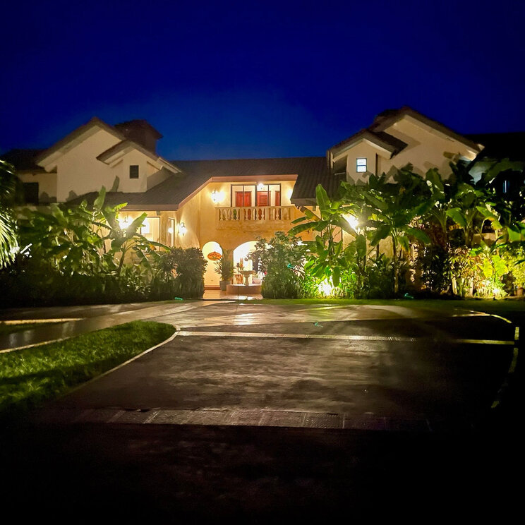 Beleuchtete Fassade des El Regalo Resorts bei Nacht mit Palmen und einer Einfahrt in Panama.