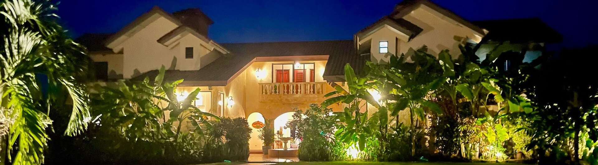 Beleuchtete Fassade des El Regalo Resorts bei Nacht mit Palmen und einer Einfahrt in Panama.