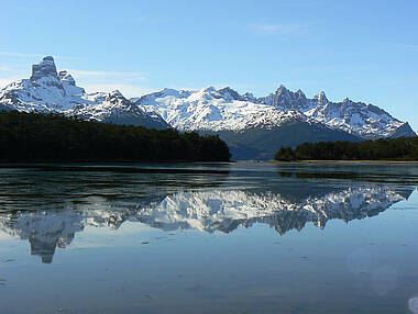 Kristallklarer Bergsee und sich spiegelnde Schneelandschaft in Ushuaia