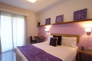 Hotelzimmer mit lila Farbakzenten im Mine Hotel