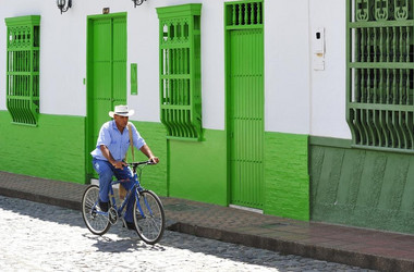 Fahrradfahrer vor einem Haus in Kolumbien