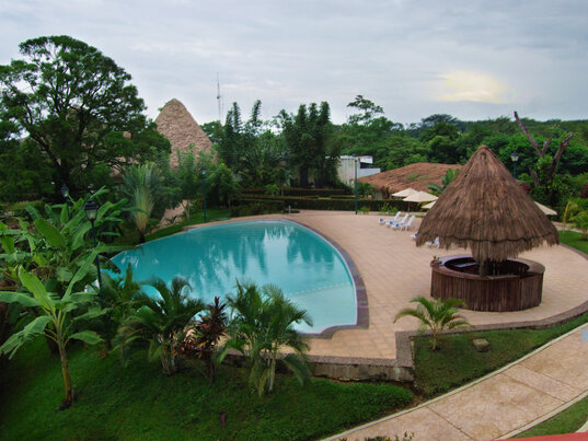Poolbereich im Hotel Villa Mercedes in Palenque mit tropischem Garten, Rundpool und Palapa-Dach.