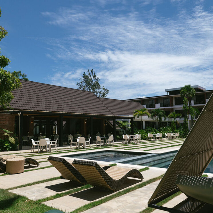 Poolbereich des Hotels Pinar Dorado in Jarabacoa in der Dominikanischen Republik mit modernen Liegen und Gartenanlage.