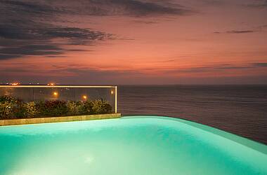 Blick bei Abenddämmerung vom beleuchteten Pool übers Meer im Hotel Irotama Resort, Santa Marta