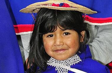 Kolumbien-Rundreisen: Mädchen in traditionell blau-rotem Gewand in San Agustín 