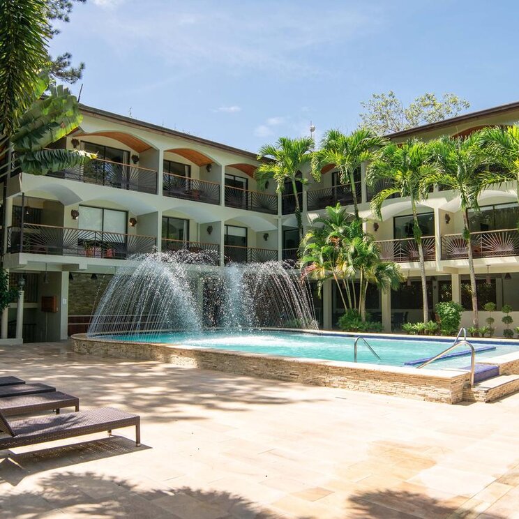 Das Bild zeigt eine Anlage des Hotel Gran Jimenoa mit Swimmingpool und umgebenden Palmen in Jarabacoa, Dominikanische Republik.