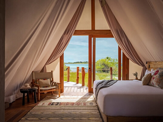 Zelt-Suite im Hotel Our Habitas Bacalar mit gemütlicher Einrichtung und Blick auf die Lagune.