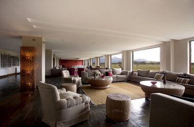 Außenansicht des Hotels Rio Serrano vor der Bergkulisse des Torres del Paine Nationalparks in Chile.