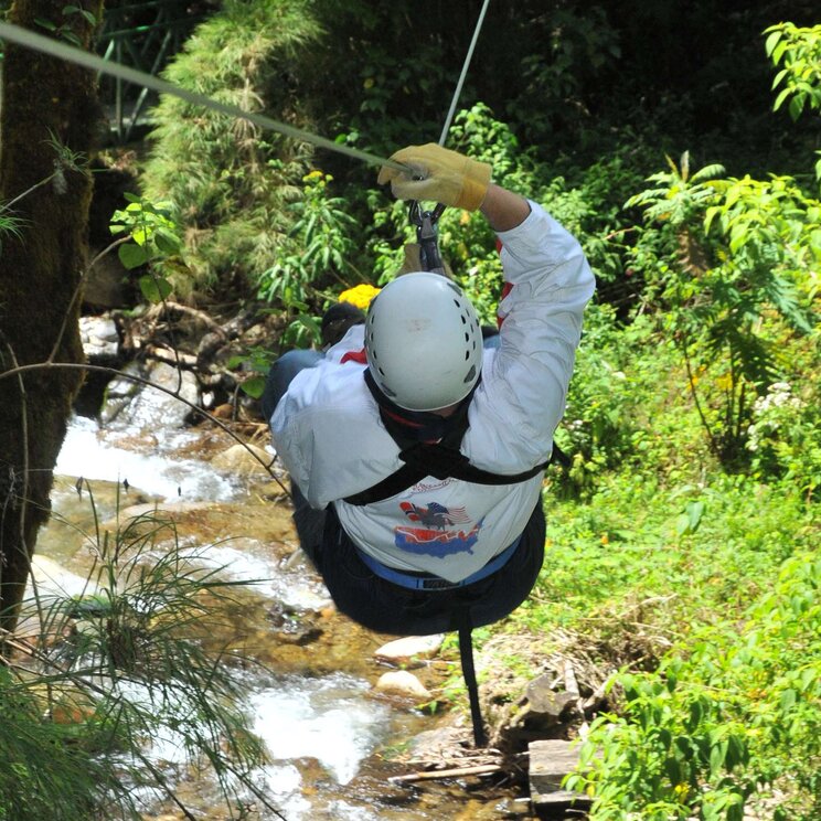 Ziplining-Erlebnis im Canopy-Bereich des Trogon Lodge, mit Blick auf den Fluss und die grüne Natur.