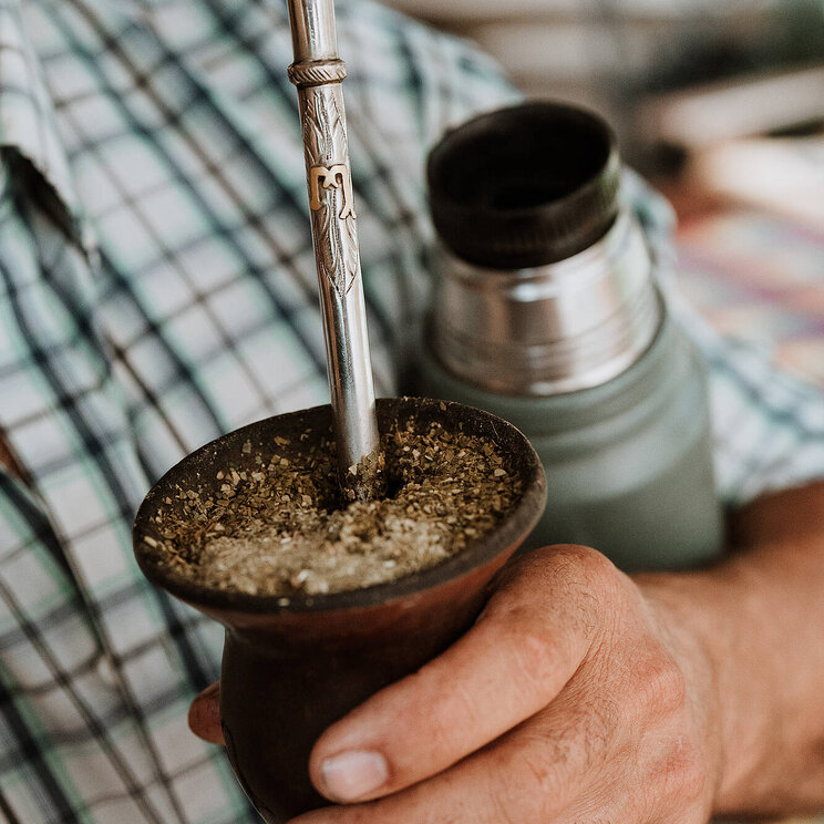 Mann hält Matebecher in der Hand