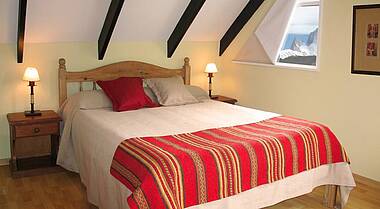 Bett mit rotem Überwurf im Hotel La Aldea
