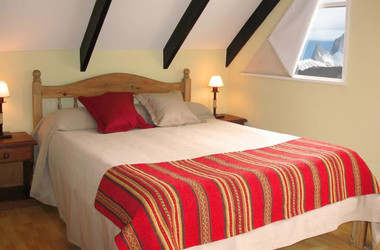Bett mit rotem Überwurf im Hotel La Aldea