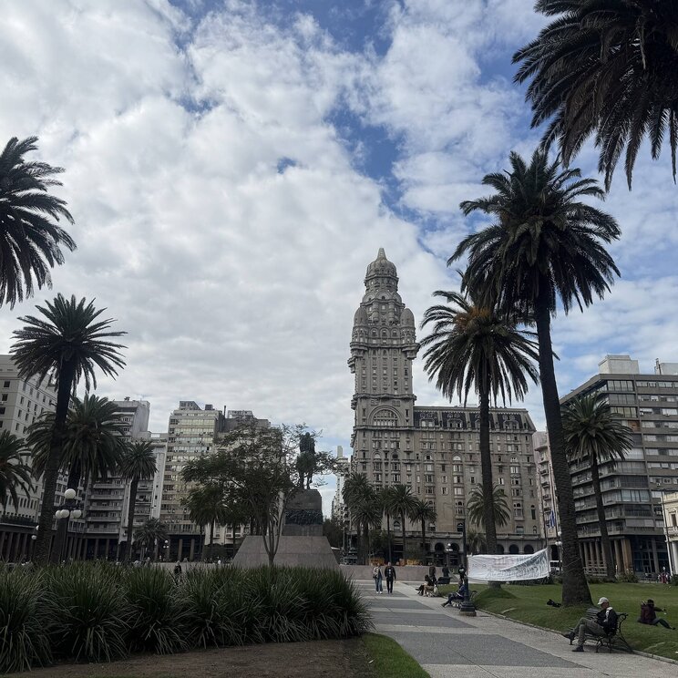 Der Palacio Salvo steht auf der Plaza Independencia in Montevideo, umgeben von Palmen und einem Park