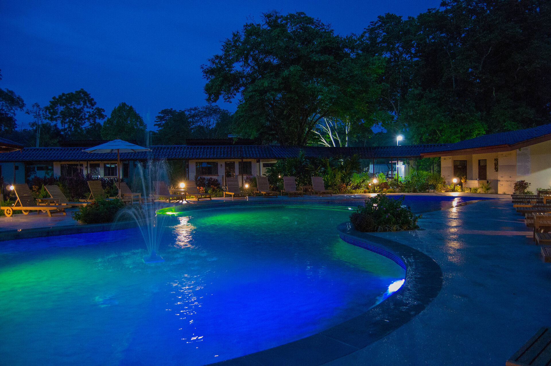Restaurant im La Foresta Nature Resort in Manuel Antonio, Costa Rica, mit Blick auf den Poolbereich und stimmungsvoller Abendbeleuchtung.