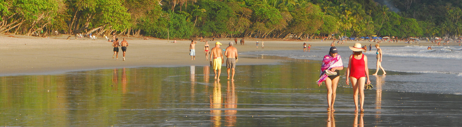 Strandspaziergang in Manuel Antonio, Costa Rica, mit tropischer Küstenlandschaft im Hintergrund.