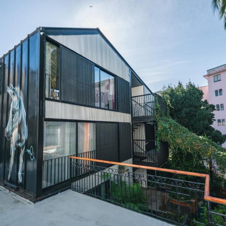 Modernes schwarzes Gebaeude mit Wandmalerei eines Pferdes und Glasfronten in Valparaiso.