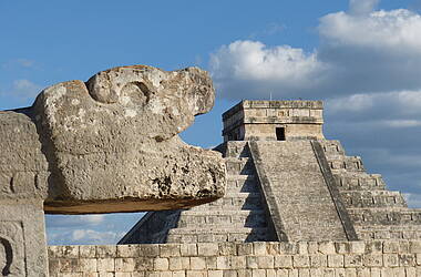 Schlangenkopf mit Kukulkan-Pyramide im Hintergrund in Chichen Itza - Mexiko