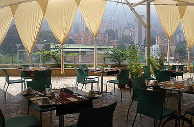 Speisebereich mit Blick auf die Skyline von Medellín im Diez Hotel Categoría Colombia