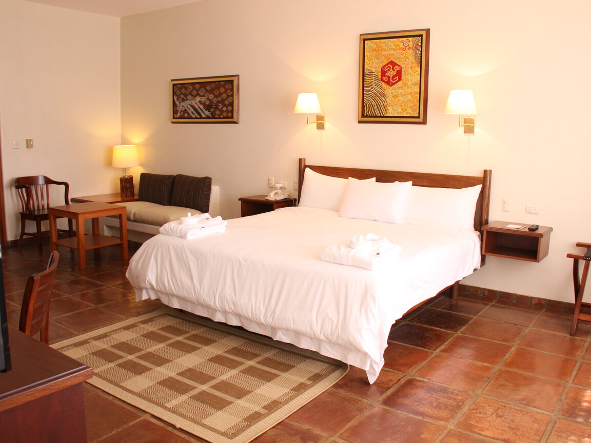 Hotelzimmer mit Doppelbett, Fliesenboden und Wandkunst in Paracas, Peru.