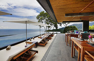Lounge des Hotels Kura Design Villas mit Sonnenliegen und Infinitypool