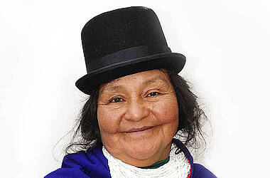 Frau in tradioneller kolumbianischer Tracht mit Hut und Perlenkette