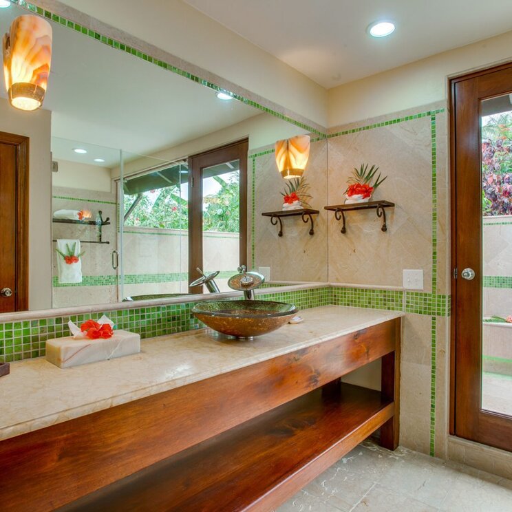 Modernes Badezimmer mit Doppelwaschtisch aus Holz, grünen Mosaikfliesen und großem Spiegel in Belize.