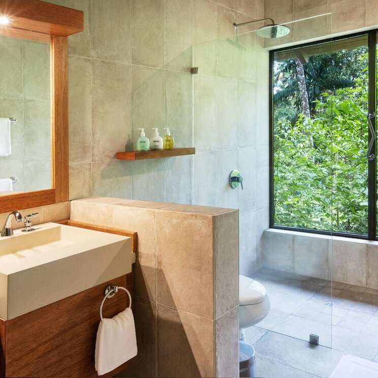 Modernes Badezimmer einer Suite mit Doppelwaschbecken und grossem Fenster zum Dschungel, Sacha Lodge.