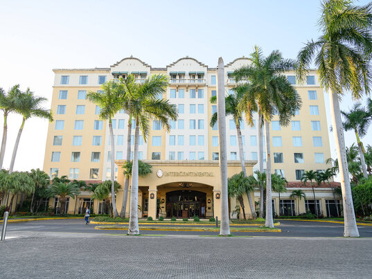 Außenansicht des Hotel Real Continental in Managua, Nicaragua, mit eleganter Fassade, Palmen gesäumter Einfahrt und klassischer Architektur.