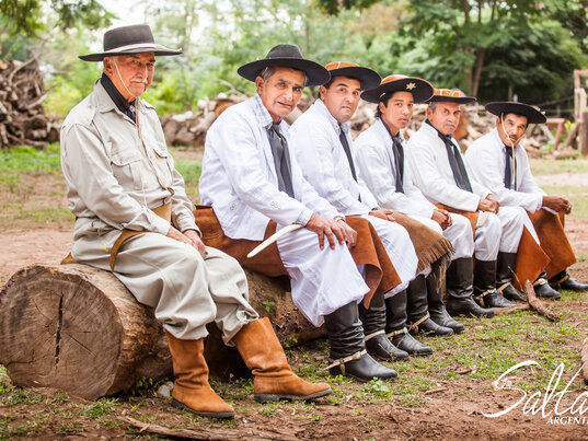 Gauchos sitzen auf einem Baumstamm in Salta