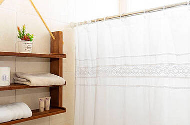 Regal mit Handtuch und Pflegeprodukten in einem Bad im Hotel Albatros