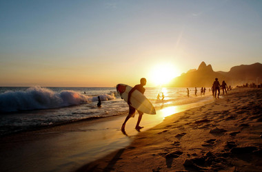 Surfer am Strand vor tiefstehender Sonne