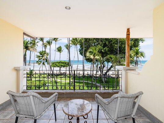 Balkon mit Fliesenboden, zwei Korbsesseln und Blick auf den Strand von Tamarindo in Costa Rica.