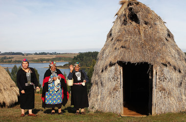 Indigene neben Hütte