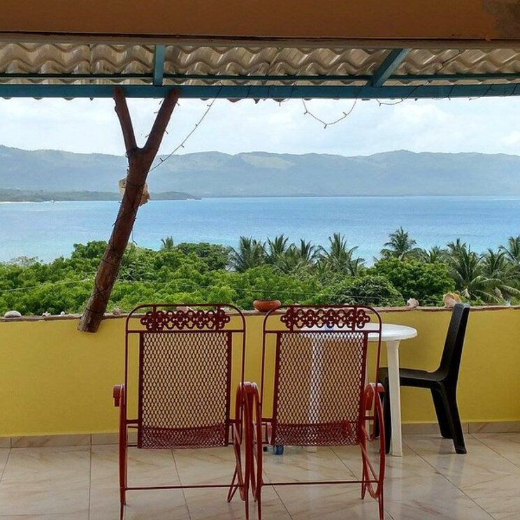 Terrasse im Hotel Corales in Punta Rucia in der Dominikanischen Republik mit Meerblick und Sitzgelegenheit.