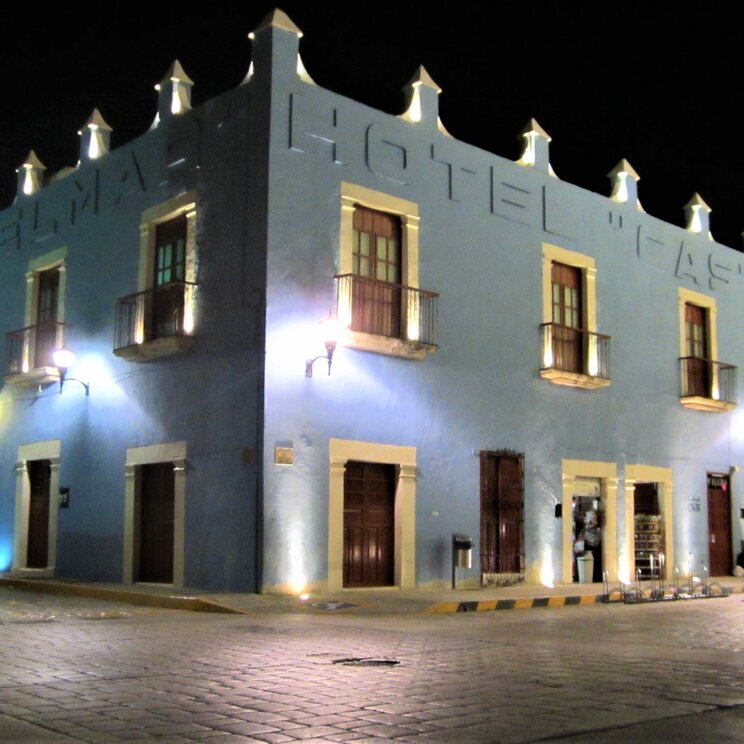 Fassade des Hotels Castelmar in Campeche bei Nacht mit blauem Kolonialgebäude an einer Straßenecke im historischen Zentrum.