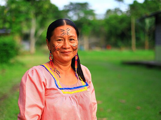 Ecuadorianische Frau mit traditioneller Kleidung und Bemalung