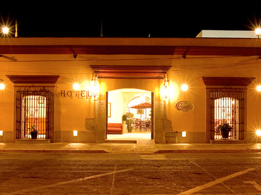 Beleuchtete Fassade des Casa Conzatti Hotels in Oaxaca bei Nacht mit Blick in den Innenhof, Mexiko.