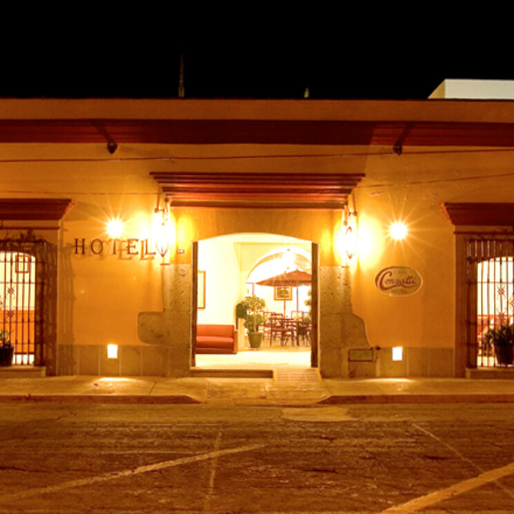 Beleuchtete Fassade des Casa Conzatti Hotels in Oaxaca bei Nacht mit Blick in den Innenhof, Mexiko.
