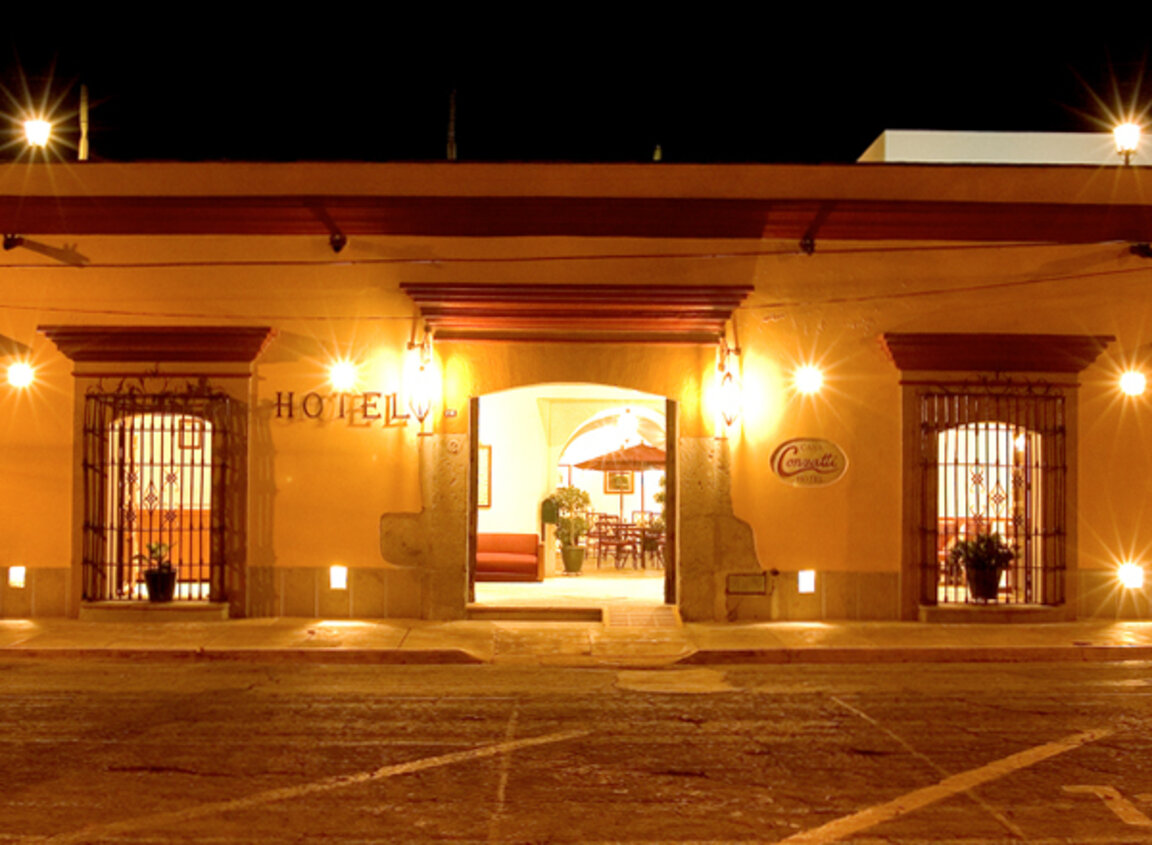 Beleuchtete Fassade des Casa Conzatti Hotels in Oaxaca bei Nacht mit Blick in den Innenhof, Mexiko.