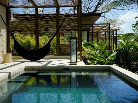 Hängematte neben einem privaten Pool im Hotel Nantipa in Costa Rica, umgeben von grüner Vegetation und modernem Design.