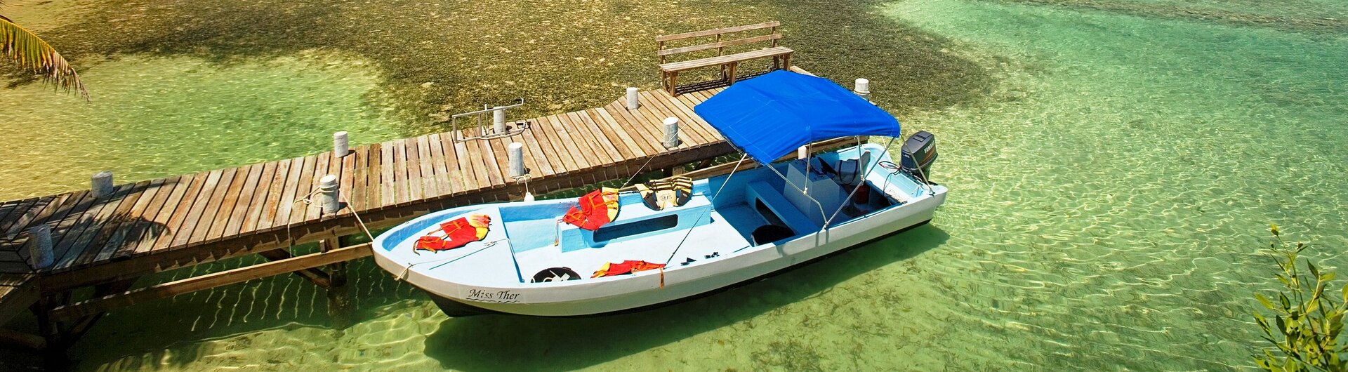 Boot am hölzernen Bootssteg in South Water Caye in Belize