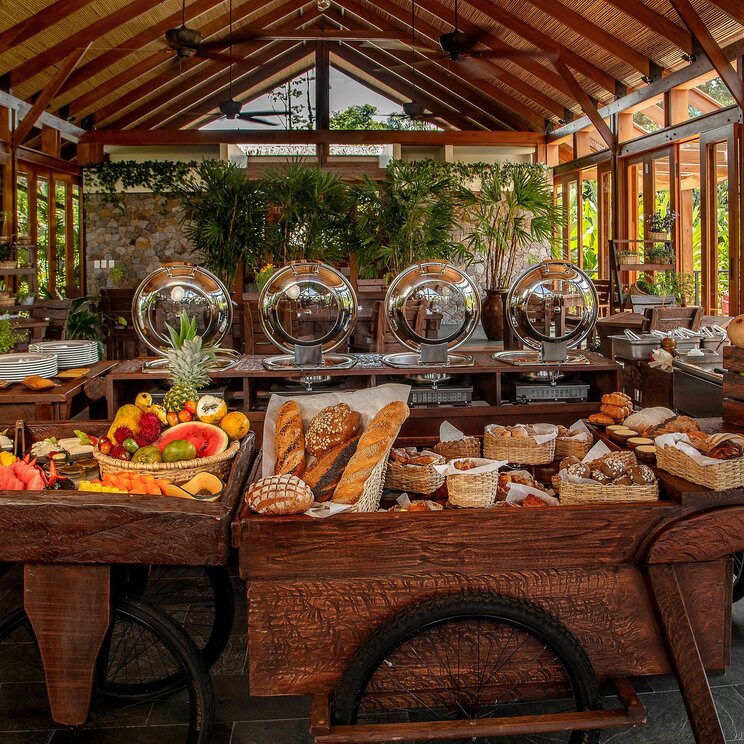 Frühstücksbuffet im Hotel Amor Arenal in La Fortuna, Costa Rica, mit großer Auswahl an frischem Obst, Gebäck und warmen Speisen in offenem Restaurant mit Blick ins Grüne.