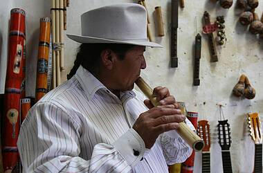 Ein Musiker spielt Flöte in Otavalo