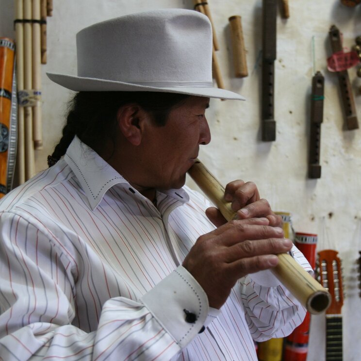 Ein Musiker spielt Flöte in Otavalo