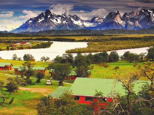 Panorama der Hotelanlage del Paine am Fluss Serrano vor dem Bergmassiv Torres del Paine in Chile.